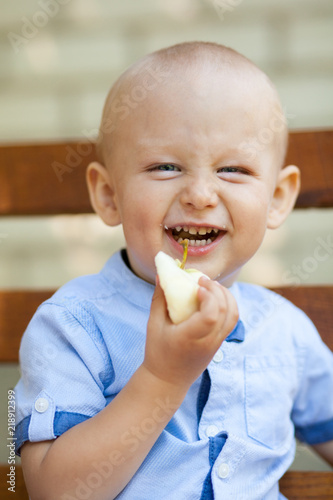 Portrait Of Baby Boy Eating green Apple. Active Cute boy eating green apple.