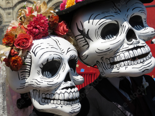 Man and woman in death masks during traditional Mexican holiday Dia de los Muertos. Day of the Dead