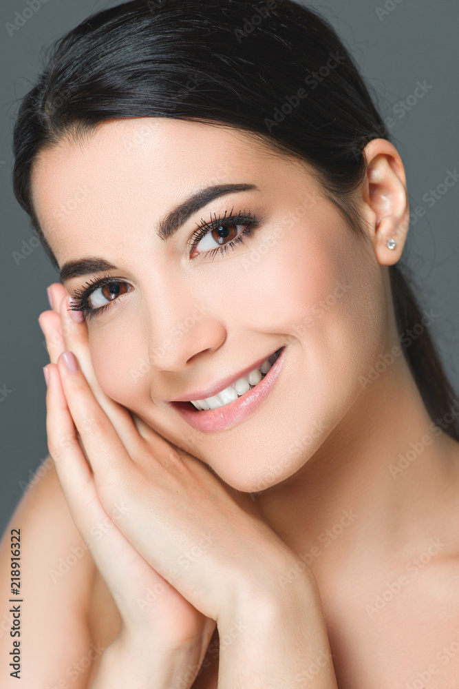 portrait of attractive smiling woman with white teeth looking at camera isolated on grey portrait of attractive smiling woman with white teeth looking at camera isolated on grey
