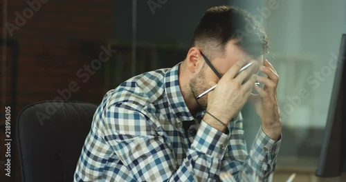 Caucasian young businessman in depression sitting in his office and thinking about his failed work project and loosing money on startup.