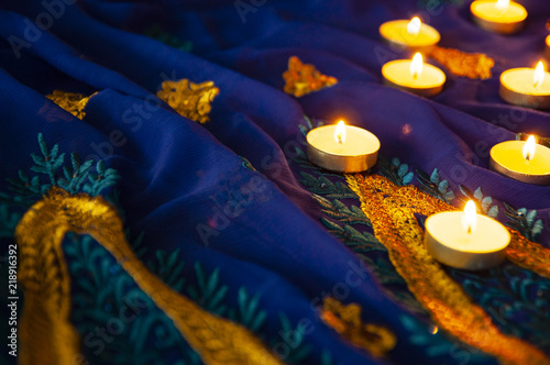 Flame candle lamps for the evening prayers. Diwali lighting on blue sari with golden embroidery