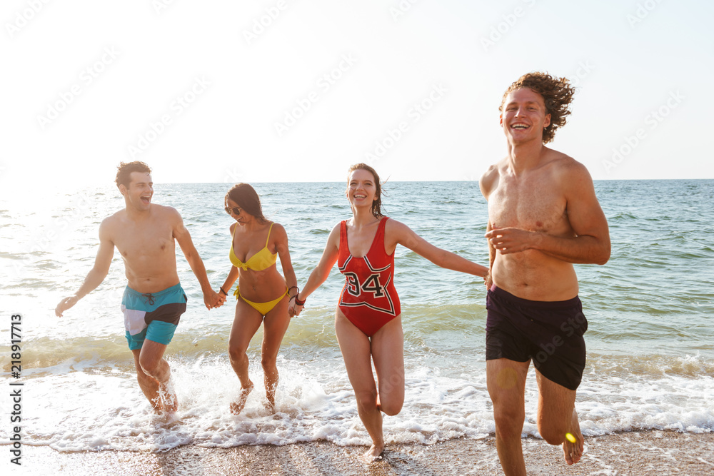 Group of friends having fun on the beach outdoors.