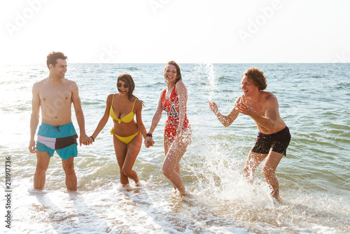 Group of friends having fun on the beach outdoors.