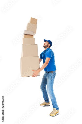 Fototapet Young delivery man with falling stack of boxes