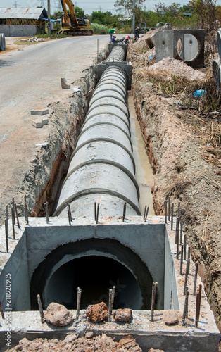 Culvert cement drainage pipe row on the construction site near the road.