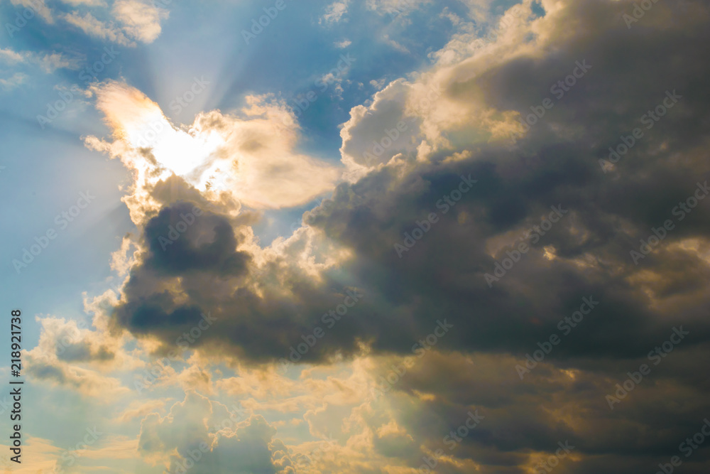 Fototapeta premium bright sun illuminating the clouds from behind with light rays