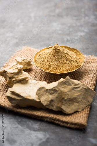 Fuller'S Earth Clay OR Multani mitti in a bowl along with raw stones and mortar photo