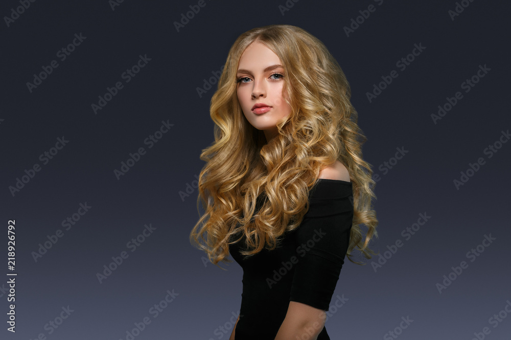 Blonde hairstyle woman beauty with long curly blonde hair over dark background Blonde hairstyle woman beauty with long curly blonde hair over dark background