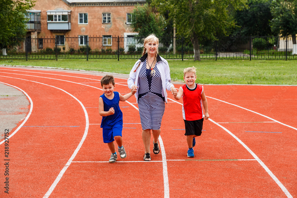 Obraz premium family run at the stadium in summer