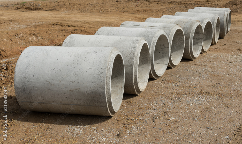 Row of Concrete Drainage Pipe on a Construction Site .Concrete pipe stacked sewage water system aligned on site