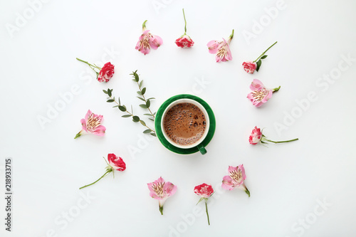 Flowers with cup of coffee on white background