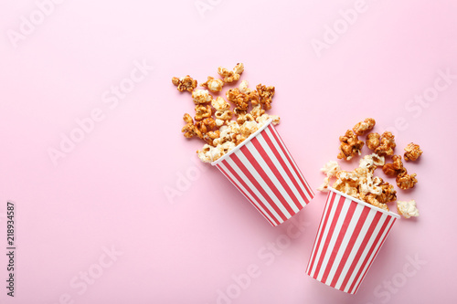 Caramel popcorn in paper cups on pink background