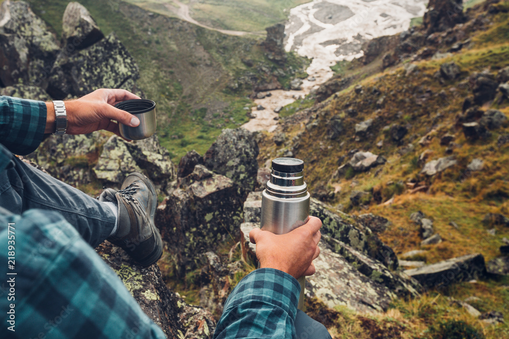 Hiking Adventure Tourism Vacation Holiday Concept. Unrecognizable Traveler Man Holding Thermos In His Hand And Enjoy View Of Summer Valley, Rear View