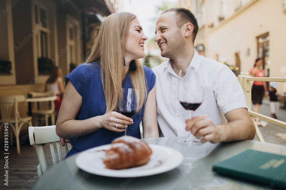 Cheerful couple in a restaurant with glasses of red wine. Young Cheerful couple in a restaurant with glasses of red wine. Young