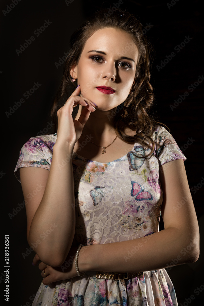 young elegant woman with professional hairstyle poses on a dark background. young elegant woman with professional hairstyle poses on a dark background.