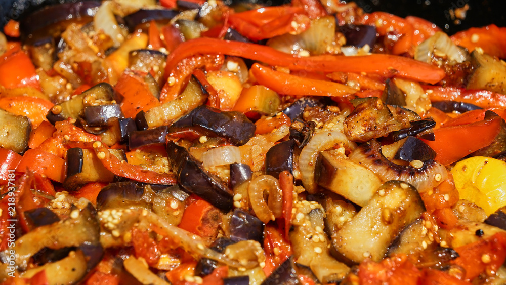 Vegetable Ratatouille in frying pan on a wooden table.