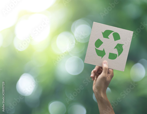 Hand holding recycle symbol on green bokeh background. eco and save the earth concept.