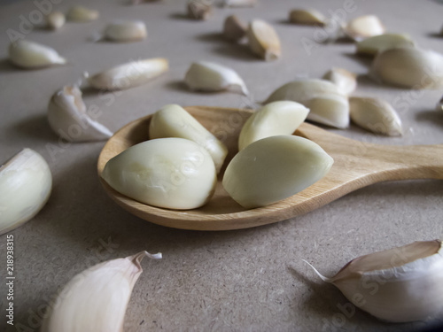 Garlic Cloves in a Wooden spoon on the MDF wooden plate board Texture Background