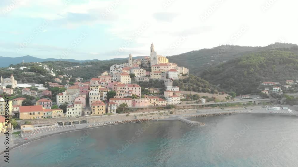 Aerial: flying around Cervo medieval town on the mediterranean coast, Liguria riviera, Italy, with the beautiful baroque church and tower bells. Native Cinelike D-Log ungraded flat color profile