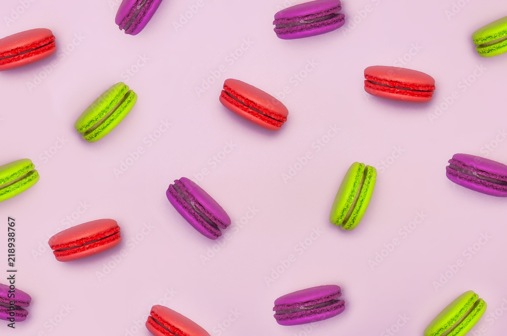 Pattern sweet macaroons on pink background top view flat lay. Delicious breakfast, beautiful dessert, colorful almond cookies, pastel colors. Pattern sweet macaroons on pink background top view flat lay. Delicious breakfast, beautiful dessert, colorful almond cookies, pastel colors.