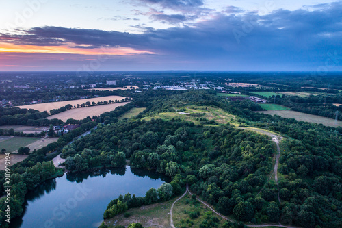 Aerial view of amazing sunset over the park in Germany. Hill and lake from birds eye view. 