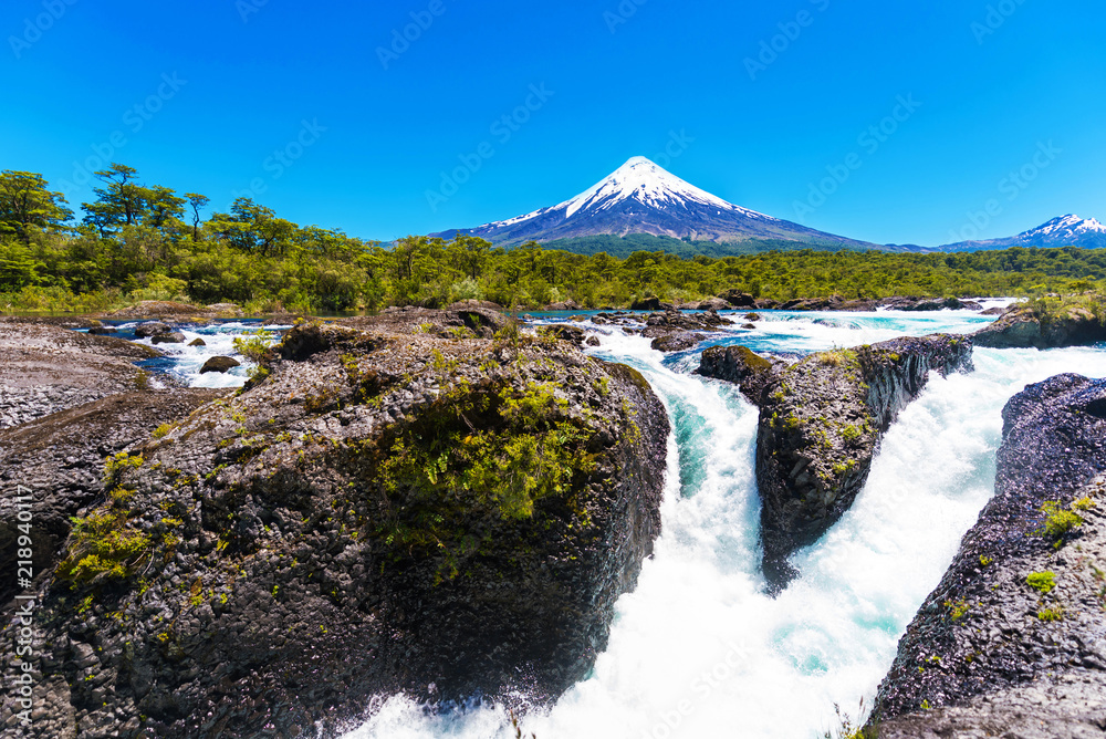 Obraz premium Salutos de Petrohue waterfalls and volcano Osorno, Puerto Varas, Chile. Copy space for text.