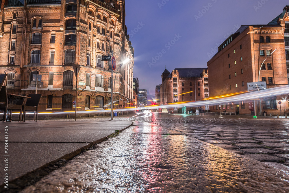 Warehouse district of Hamburg (Speicherstadt) at night. Nice reflections after rain is gone. Light trails.