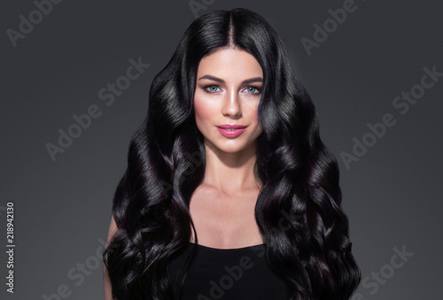 Black hair woman. Beautiful brunette hairstyle fashion portrait over dark background
