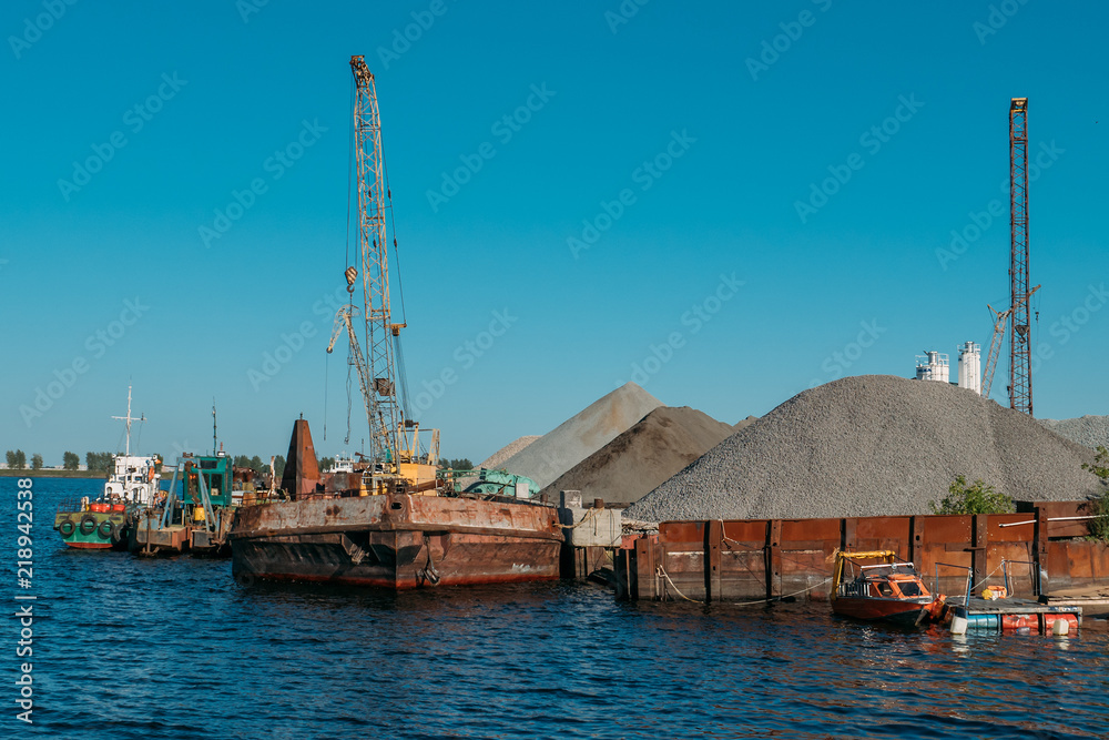 Industrial cargo port with old ships on river, water logistics