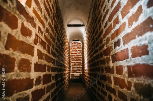 Ancient narrow brick tunnel or corridor of medieval castle, way to freedom concept