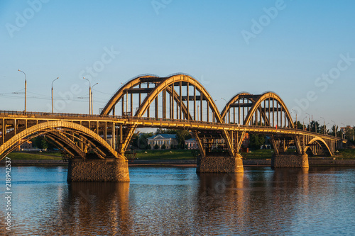 Volga bridge and embankment over Volga river at sunset, Yaroslavl region, Rybinsk city, Russia. Beautiful landscape