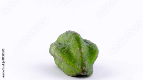 One whole mountain papaya fruit named paw-paw. Slowly rotating on the turntable isolated on the white background. Close-up. Macro. photo