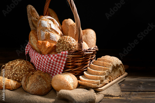 Bread and rolls in wicker basket on burlap sack