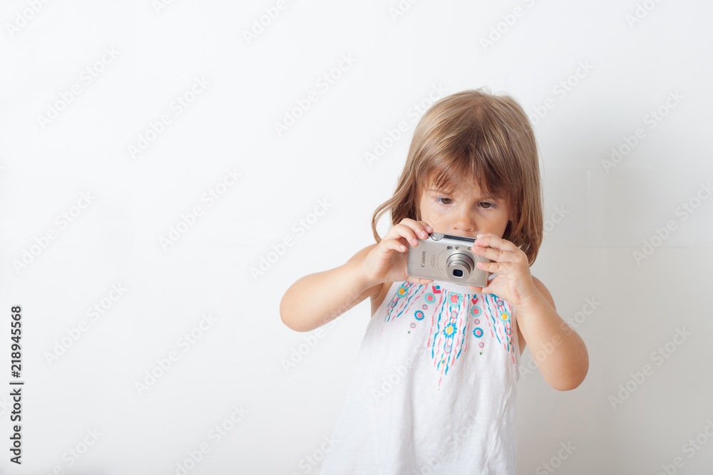 Cute little girl with camera on white- gray background Cute little girl with camera on white- gray background
