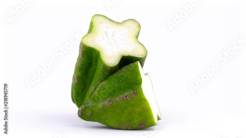 Two halves of mountain papaya fruit named paw-paw. Slowly rotating on the turntable isolated on the white background. Close-up. Macro. photo