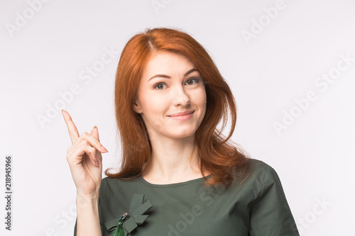 Fashion, creative and people concept - young woman show that she has an idea over the white background photo