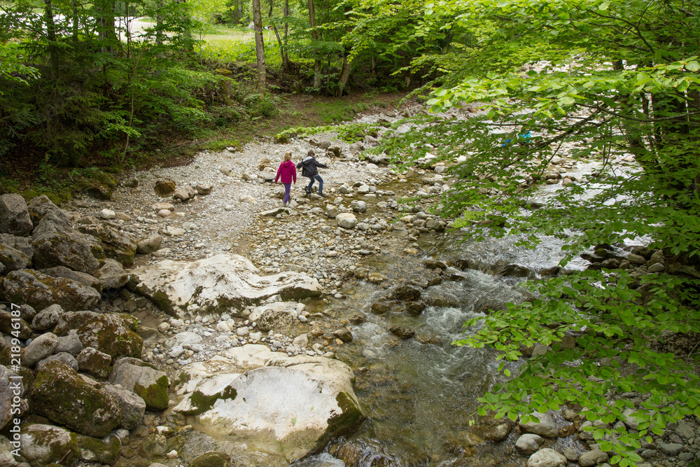 Kinder wandern in Flussbett
