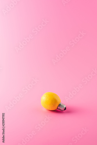 close-up view of light bulb made of lemon on pink