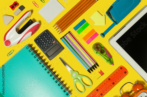 Slika na platnu different school and office stationary and gadgets lying on a yellow surface