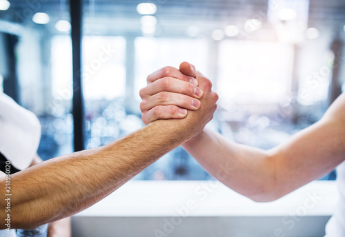A friendly handshake of two young men in crossfit gym.
