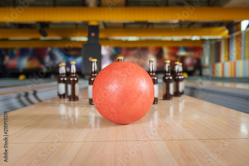 Absolute strike. Selective focus of a bowling ball hitting bottles with beer