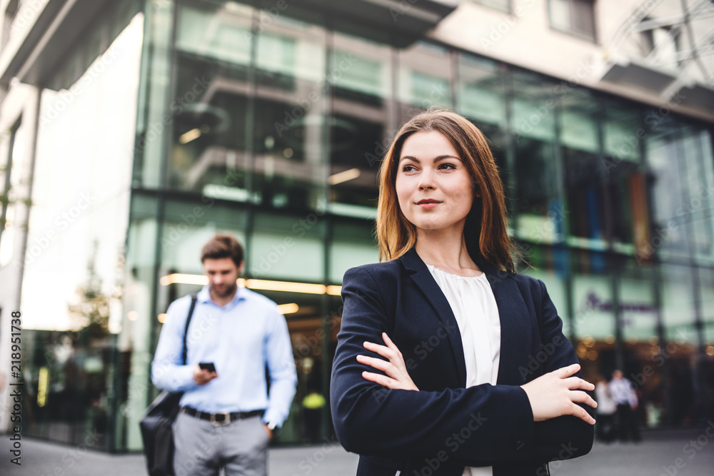 A portrait of a young businesswoman standing outdoors in front of a building.