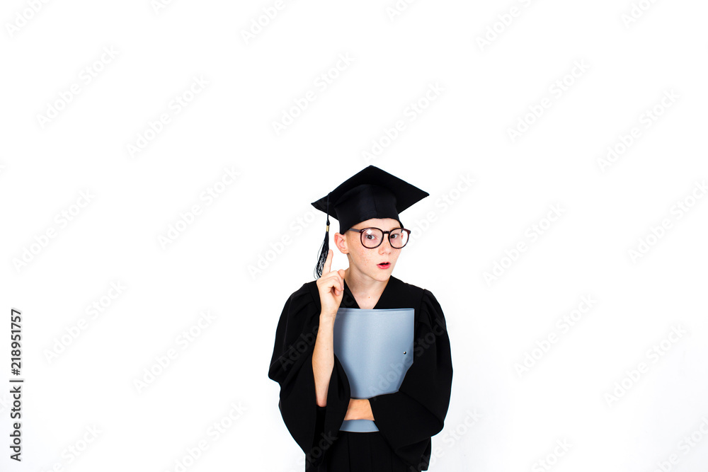A smart student in an academic hat and glasses stands with books. Educational concept. Isolated on white background A smart student in an academic hat and glasses stands with books. Educational concept. Isolated on white background