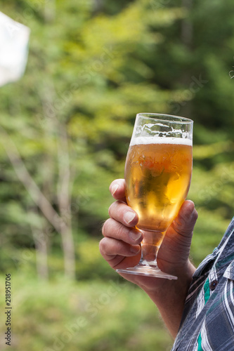 Main d'homme tenant un verre de bière photo