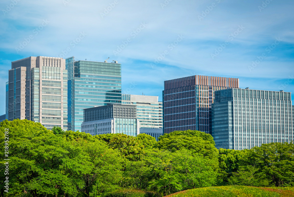 Modern building with green garden on blue sky background in Tokyo, Japan.