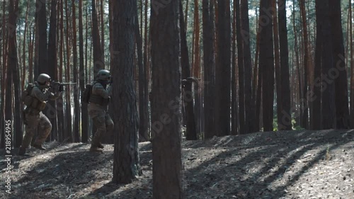 Soldiers of the US Army are running to attack in a smoky forest