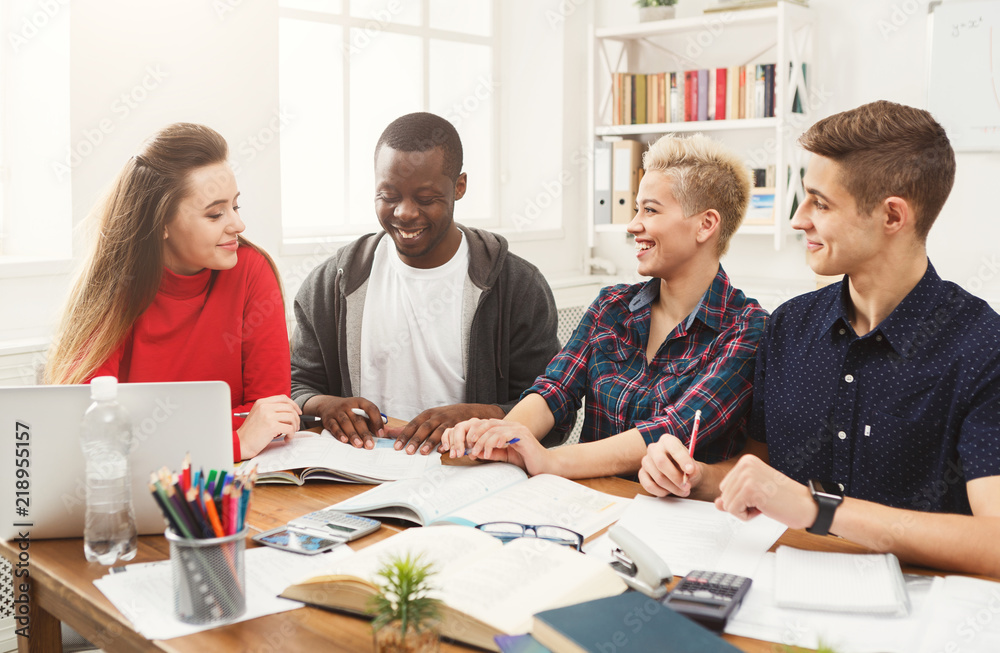 Group of diverse students studying at wooden table Group of diverse students studying at wooden table