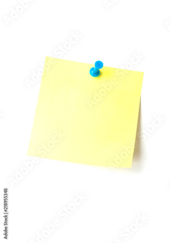 closeup of yellow adhesive sticker with blue pin on white background