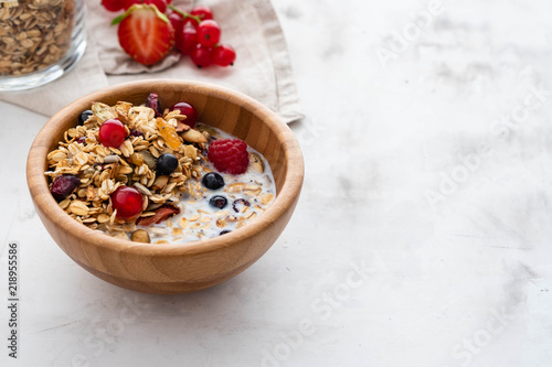 Homemade granola in bowl rustic background. Copy space.