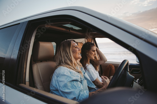 two attractive women driving truck at beach photo